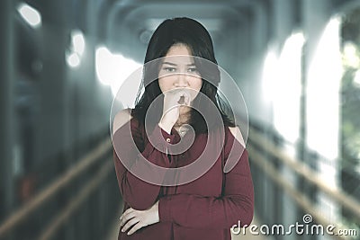 Sad woman looks confused on the pedestrian bridge Stock Photo