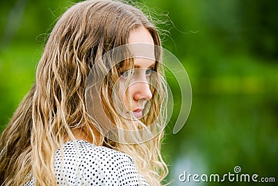 Sad young fashion woman with long curly hairs outdoor Stock Photo