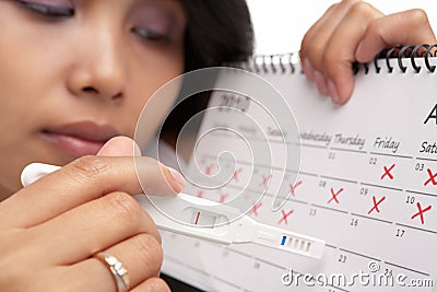 Sad woman, negative pregnancy test & calendar Stock Photo