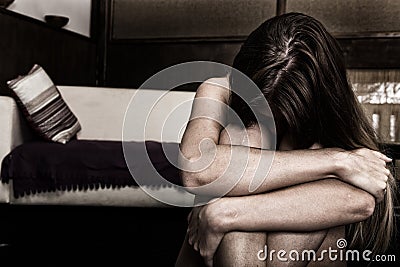 Sad woman sitting alone in a empty room next to the bed. domestic violence Stock Photo
