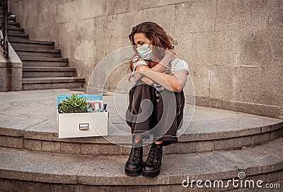 Sad woman sitting outside office feeling hopeless after being fired. Coronavirus job cuts crisis Stock Photo
