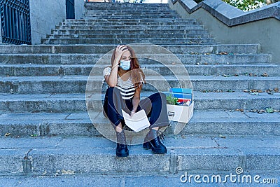 Sad woman sitting outside office feeling hopeless after being fired. Coronavirus job cuts crisis Stock Photo