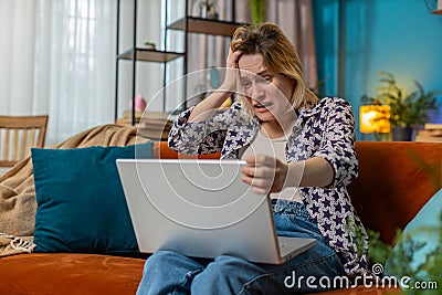 Sad woman using laptop notebook typing browsing working loses bad news game fail computer virus Stock Photo