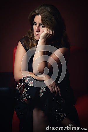 Sad, worried or nostalgic woman sitting lonely Stock Photo