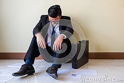 Sad Asian businessman sit on floor Stock Photo