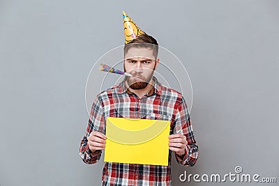 Sad young bearded birthday man holding copyspace board Stock Photo