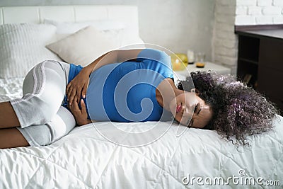 Beautiful Hispanic Girl Feeling Pain During Period Stock Photo