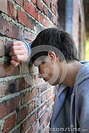 Sad Young Man by the Wall Stock Photo