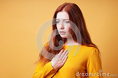 sad young woman with hand on chest feeling heartache or heartburn Stock Photo