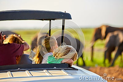 Safari holiday. Blond children watching african elephants from roof of a safari car. Editorial Stock Photo