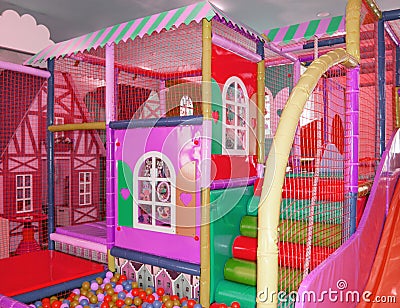 Safe colorful children's trampoline with a net and colorful balls in the form of a house on the playground, indoors Stock Photo