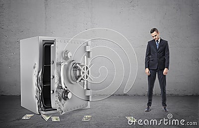 Safe with its door broken open and disappointed businessman full height Stock Photo