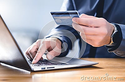 Safe online payment and electronic money transfer security. Pay with digital technology. Man using credit card and laptop. Stock Photo