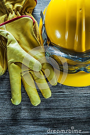 Safety gloves building helmet goggles on vintage wooden board Stock Photo