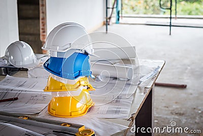 The safety helmet and the blueprint on table at construction site Stock Photo