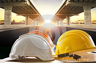 Safety helmet on civil engineering working table against bridge Stock Photo