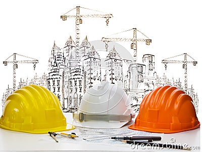 Safety helmet on engineer working table against sketching of building construction and high crane safety helmet on engineer Stock Photo