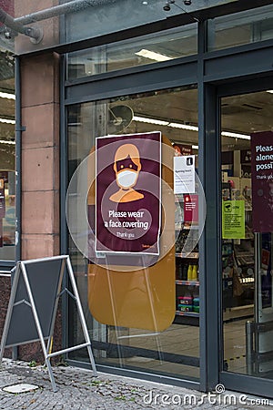 Safety information sign at entrance to shop for people to wear face masks Editorial Stock Photo