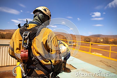 Safety trained supervisor using defocused an inertia reel shock absorbing fall arrest device onto back of harness Stock Photo