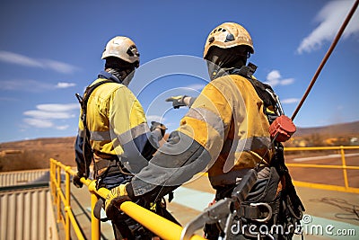 Safety trained supervisor using defocused an inertia reel shock absorbing fall arrest device onto back of harness Stock Photo