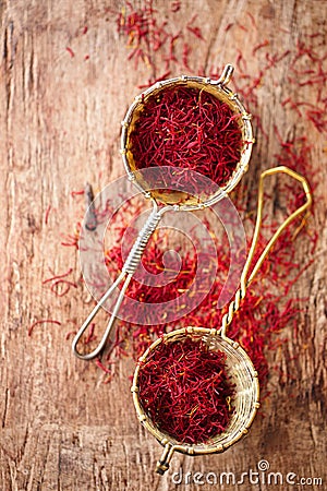 Saffron spice in rustic sieve on old wooden background Stock Photo