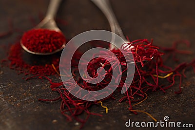 Saffron spice threads and powder in vintage old spoons Stock Photo