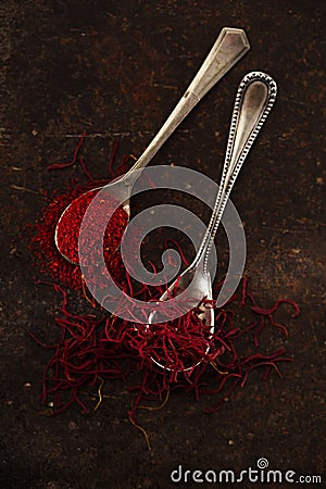 Saffron spice threads and powder in vintage old spoons Stock Photo