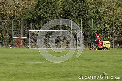 Man trims the turf of a stadium with a stadium grass cutter machine Editorial Stock Photo