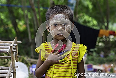 Sagaing/Myanmar-October 3rd 2019: A Burmese girl wears flashy colors and fingers in balloons of various colors Editorial Stock Photo