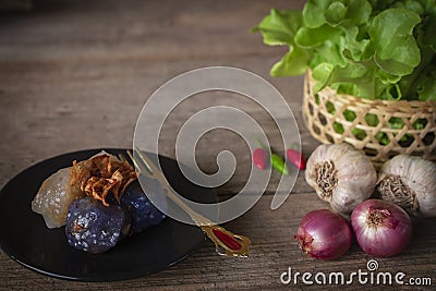 Sago pork in circle black plate with fried garlic toping have chilli ,Shallot, garlic, lettuce basket place right hand and gold Stock Photo