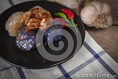 Sago pork in circle black plate with fried garlic toping have garlic place backside and chilli place on black plate on tablecloth Stock Photo