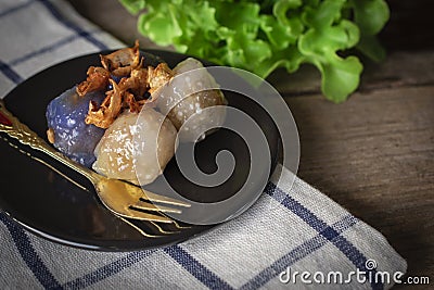 Sago pork in circle black plate with fried garlic toping have lettuce place backside and gold fork place on black plate on Stock Photo