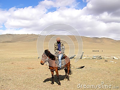 SAGSAY, MONGOLIA - MAY 22, 2012: Mongolian horseman shepherd his of sheep in the desert Editorial Stock Photo