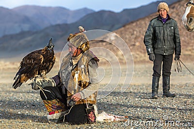 Berkutchi Eagle Hunter while hunting to the hare with a golden eagles on his arms Editorial Stock Photo