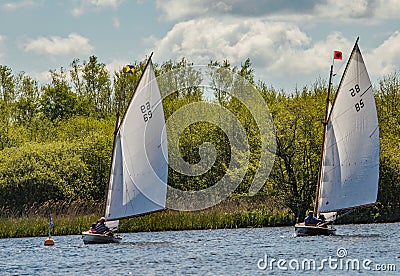 Two traditional brown boats racing to the buoy on Wroxham Broad, Norfolk Editorial Stock Photo