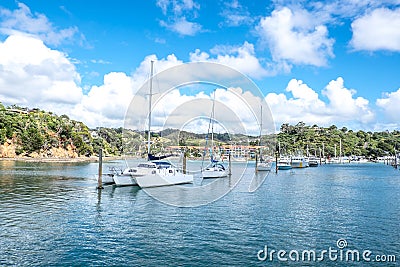 Sail boats and motor launches at pile moorings in entrance to Tu Stock Photo