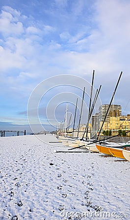 Sail boats on a pebble beach on a frozen snowy frosty morning Stock Photo