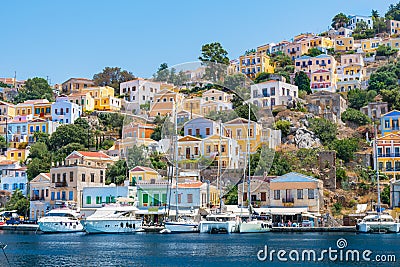 Sail boats, yachts and colorful houses in harbor town of Symi Symi Island, Greece Stock Photo