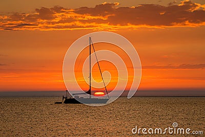 Sailboat at anchor with beautiful sunset in the background Stock Photo