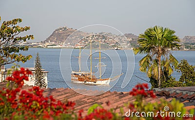 Sailboat approaching a shore on a sunny afternoon Stock Photo