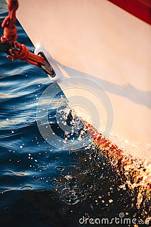 Sailboat bow cutting through the water, forward, sail and nautical rope yacht detail. Yachting, marine background Stock Photo