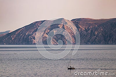 Sailboat gliding across the tranquil waters of a lake surrounded by picturesque mountains Stock Photo