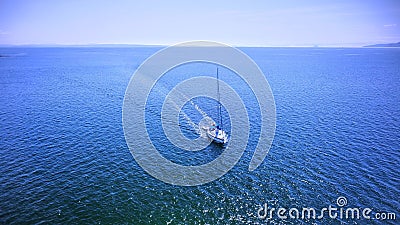 Sailboat gliding across a vast body of water, with a beautiful sky in the background Stock Photo