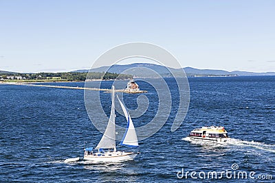 Sailboat Lifeboat and Lighthouse Editorial Stock Photo