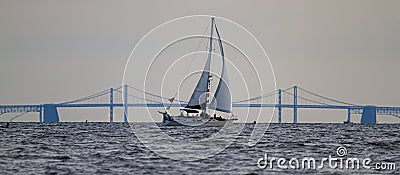 A sailboat moving across chesapeake bay at sunset Stock Photo