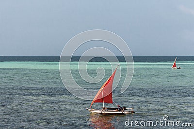 Sailboat with red sail on the sea. Reggata concept. Marine race. Yacht with red sail on tropical seascape. Summer recreation. Stock Photo