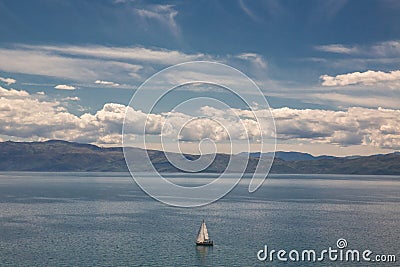 Sailboat sailing alone on Lake Ohrid on a bright summer day, Macedonia FYROM Stock Photo