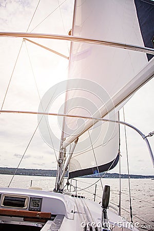 Sailboat sailing into the sun on a calm summer day Stock Photo