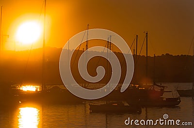 Sailboat silhouettes, magnificent golden warm sunset in Ibiza marina. Stock Photo