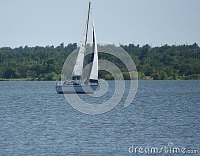 Sailboat, single mast, early afternoon sun, Lake Hefner Editorial Stock Photo